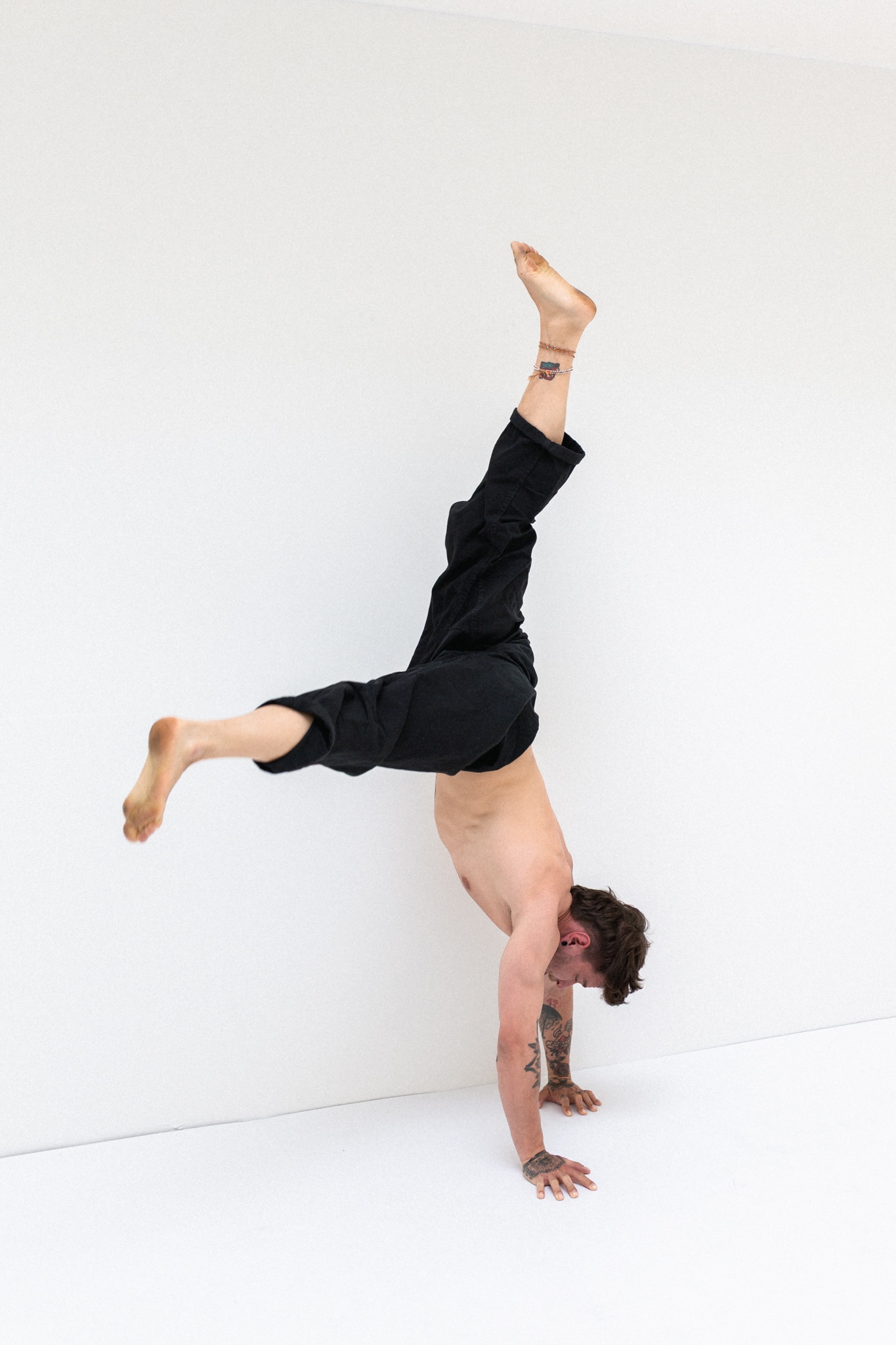 Robin demonstriert für das Handstand Online Mentoring, wie man sich sauber aus einem Handstand herausdreht in einem Bewegungsstudio in Luzern